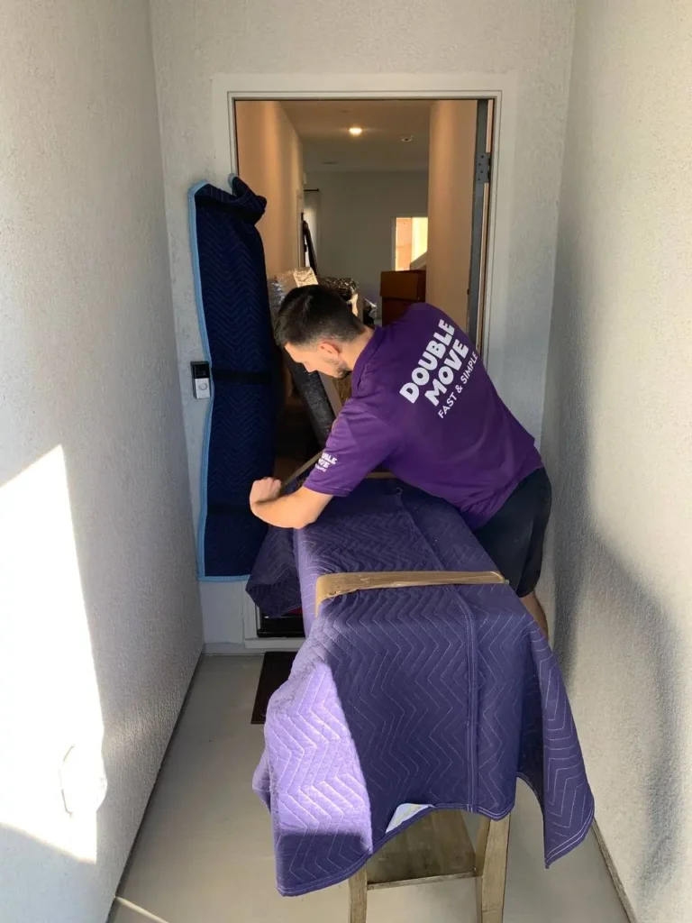 Mover wrapping furniture in protective moving pads