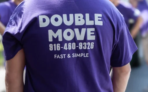 Double Move crew member seen from the back wearing a branded t-shirt with company phone number